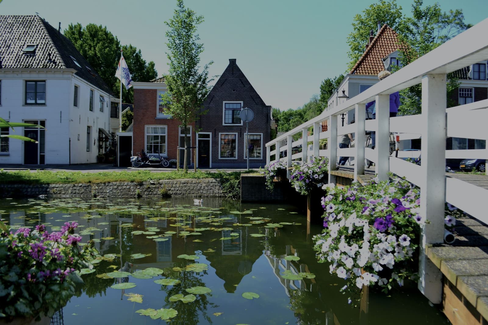 Huizen en een witte brug aan het water in Weesp